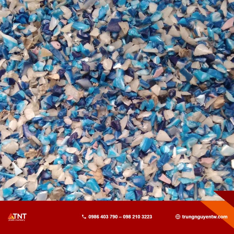 Cận cảnh hỗn hợp hạt nhựa tái chế cắt nhỏ nhiều màu sắc (xanh dương, trắng, nâu nhạt)