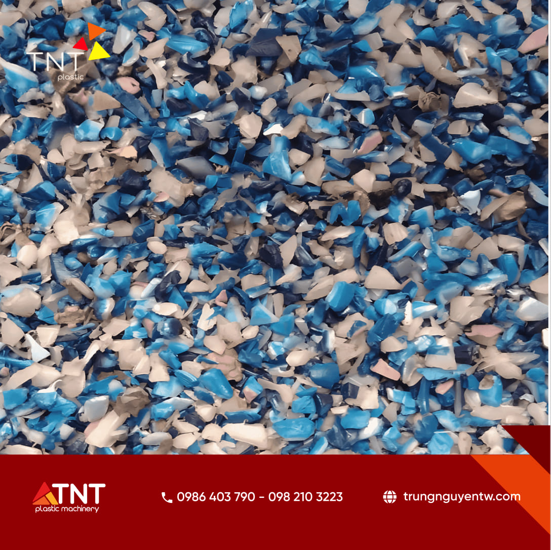 Cận cảnh hỗn hợp hạt nhựa tái chế cắt nhỏ nhiều màu sắc (xanh dương, trắng, nâu nhạt)